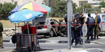 Las fuerzas de seguridad israelíes se reúnen en la escena de un ataque a la entrada del pueblo de Beit Anoun el 18 de julio de 2017. (Wisam Hashlamoun / Flash90)