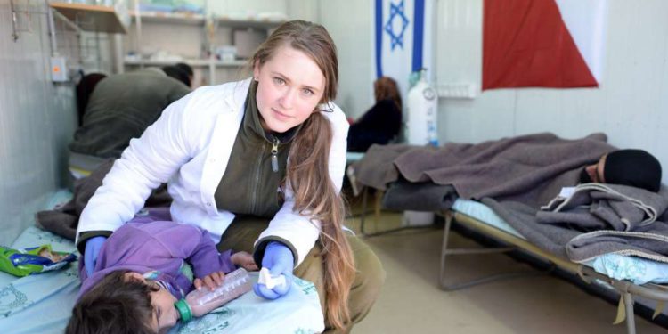 Un médico de la FID trata a una niña siria lesionada en un hospital de campo en el norte de Israel. Foto de GPO