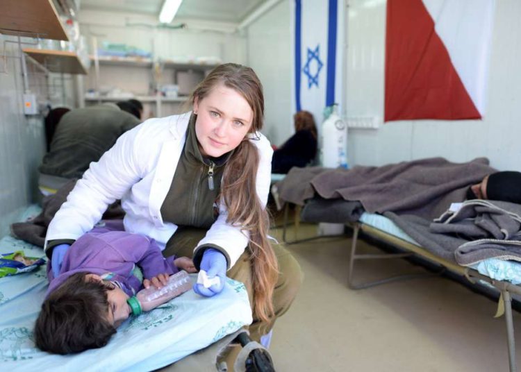 Un médico de la FID trata a una niña siria lesionada en un hospital de campo en el norte de Israel. Foto de GPO