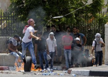Un árabe lanza una piedra con una honda contra las fuerzas israelíes durante las violentas manifestaciones después de las oraciones islámicas del viernes en la entrada principal de la ciudad de Belén el 21 de julio de 2017. (AFP / Musa Al Shaer)