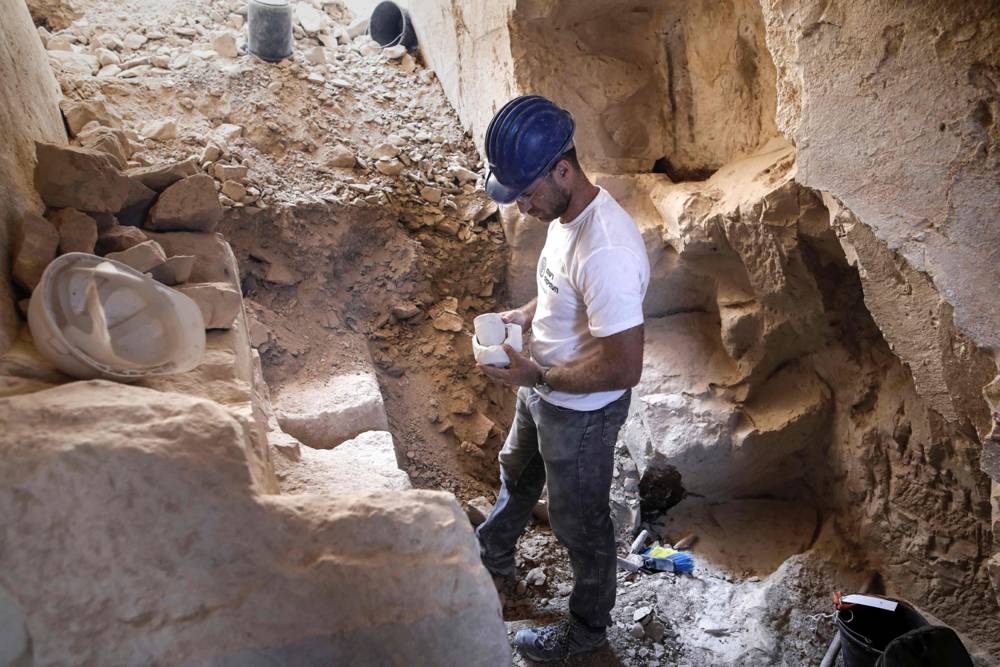 El arqueólogo israelí Yonatan Adler, director de excavaciones en el sitio, inspecciona tazones y núcleos de calcárea del sitio. MENAHEM KAHANA / AFP