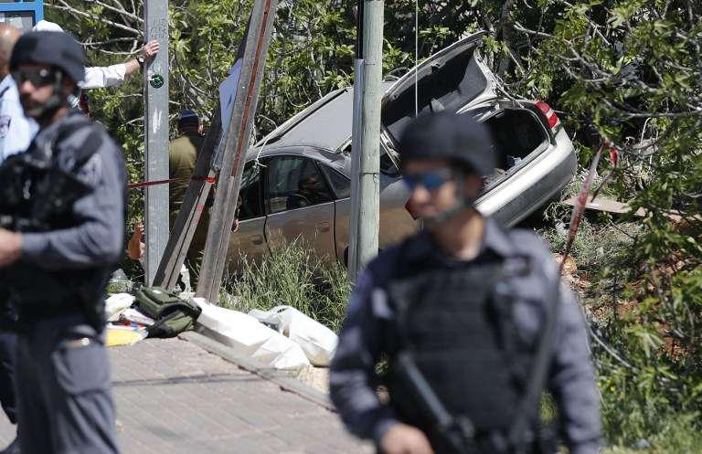 Las fuerzas de seguridad israelíes inspeccionan el sitio de un atentado islámico de embestida con auto fuera del poblado israelí de Ofra en Judea y Samaria el 6 de abril de 2017. (AFP Photo / Thomas Coex)