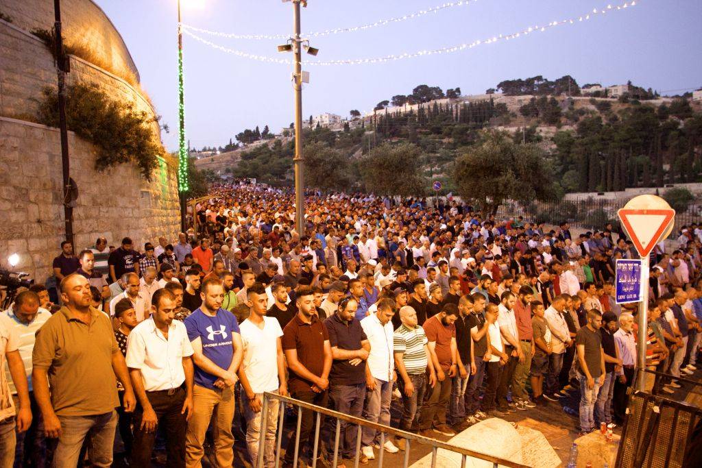 Miles de musulmanes participan en oraciones vespertinas fuera de la Puerta de los Leones en la Ciudad Vieja de Jerusalén, negándose a entrar en el recinto del Monte del Templo para llegar a la Mezquita Al-Aqsa, el 25 de julio de 2017. (Dov Lieber / Times of Israel)