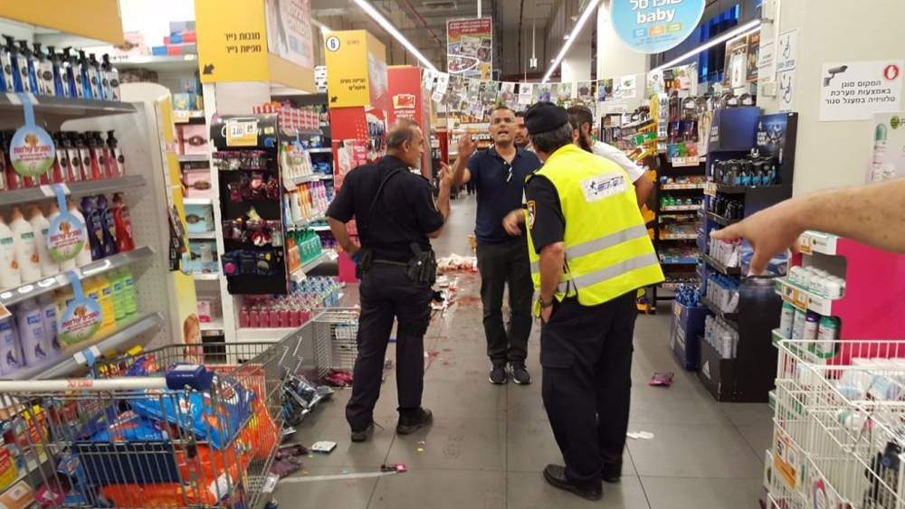La policía y los médicos responden a una puñalada en un supermercado en la ciudad israelí central de Yavneh el 2 de agosto de 2017. (United Hatzalah)