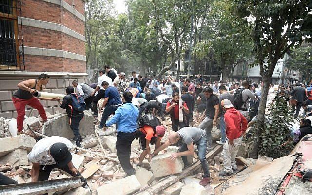 La gente retira los escombros de un edificio dañado después de un terremoto que sacudió la ciudad de México el 19 de septiembre de 2017, momentos después de que se realizó un simulacro de terremoto en la capital. (Foto AFP / Alfredo Estrella)