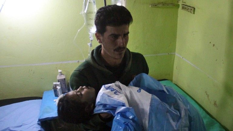 Un niño sirio inconsciente es trasladado a un hospital en Khan Sheikhoun, una ciudad controlada por los rebeldes en la provincia de Idlib, en el noroeste de Siria, tras un presunto ataque de gases tóxicos el 4 de abril de 2017. (AFP PHOTO / Omar haj kadour)