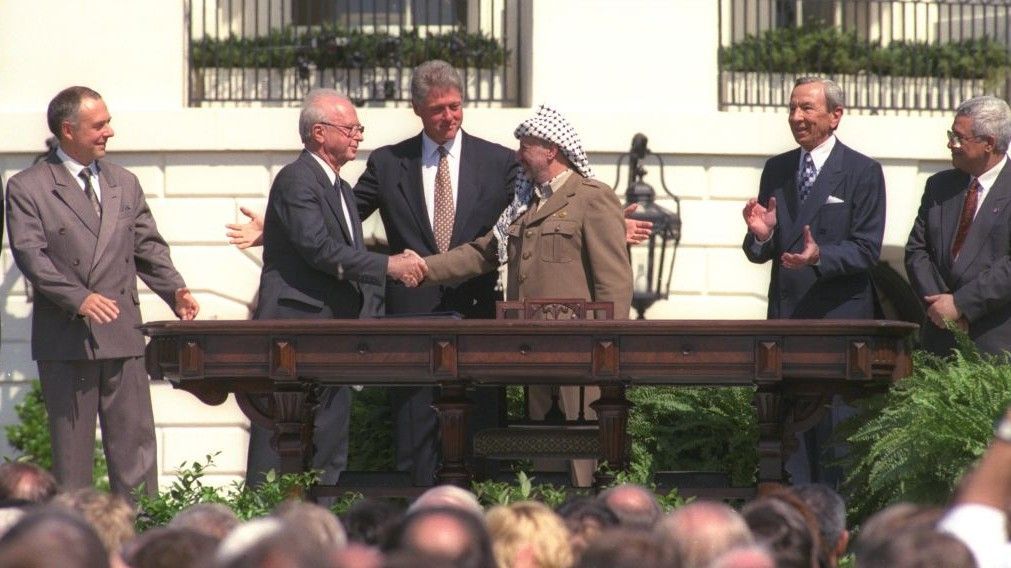 Bill Clinton observa mientras Yitzhak Rabin y Yasser Arafat se dan la mano durante la firma de los Acuerdos de Oslo, 13 de septiembre de 1993. En el extremo de la derecha, el actual líder de la Autoridad Palestina, Mahmoud Abbas (crédito de la foto: gentileza de GPO)