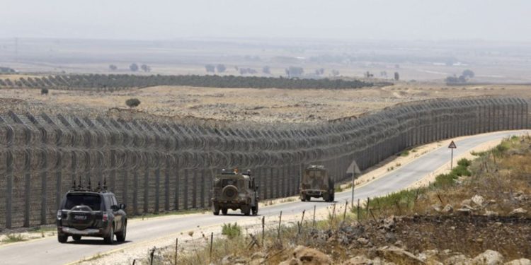 Vehículos de las FDI que conducen por la carretera paralela a la valla fronteriza que separa las regiones israelíes y sirias de los Altos del Golán, 19 de julio de 2017. (AFP / MENAHEM KAHANA)