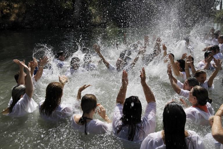 Los peregrinos evangélicos cristianos de Brasil asisten a una ceremonia de bautismo en masa, en las aguas del río Jordán en Yardenit en el norte de Israel el 7 de octubre de 2017, durante la fiesta judía de Sukkot, o la fiesta de los Tabernáculos. (AFP / MENAHEM KAHANA)