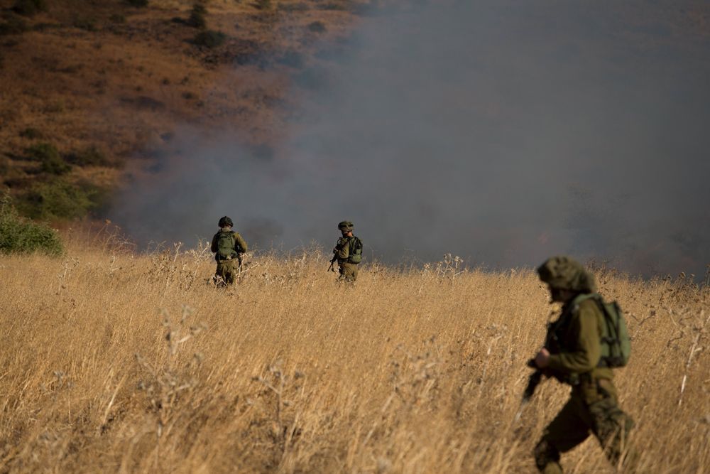Soldados israelíes buscan en la zona del impacto de un proyectil procedente de Siria