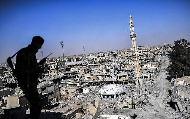 Un miembro de las Fuerzas Democráticas Sirias (SDF), respaldado por fuerzas especiales estadounidenses, conversa en la radio cerca del estadio de Raqqa cuando despeja las últimas posiciones en primera línea el 16 de octubre de 2017. (AFP / BULENT KILIC)