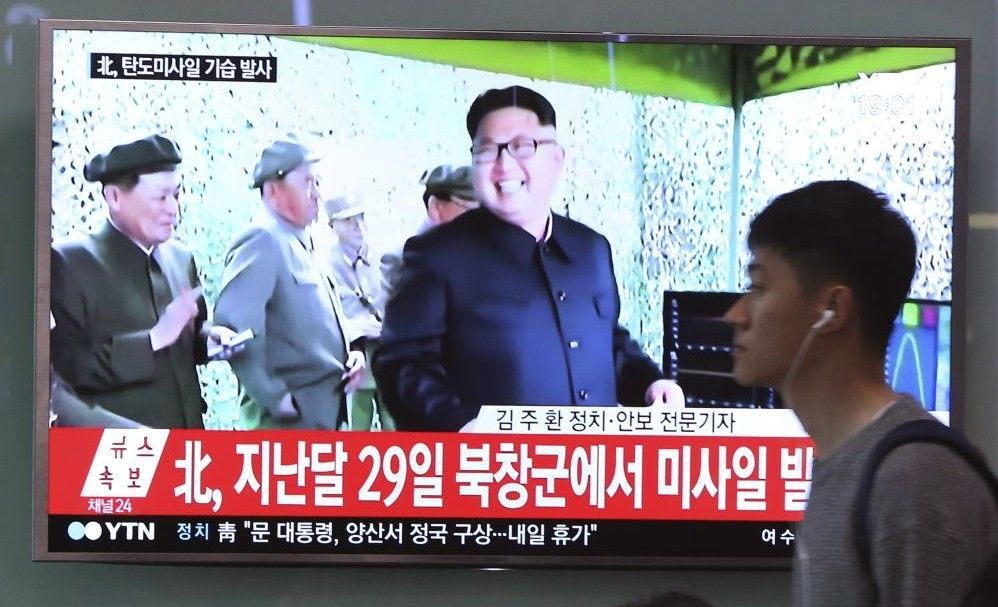 Un hombre pasa frente a una televisión donde se transmite un programa de noticias de televisión que muestra un archivo de la imagen del líder norcoreano Kim Jong Un, en la estación de tren de Seúl en Seúl, Corea del Sur, el domingo 21 de mayo de 2017. (AP Photo / Ahn Young-joon)