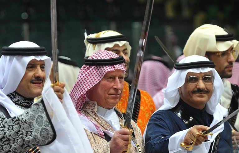 El príncipe Carlos (C) de Gran Bretaña viste un uniforme saudita tradicional cuando participa en un baile de espada "Ardah" en Arabia Saudita en 2014. (AFP / Pool / Fayez Nureldine)