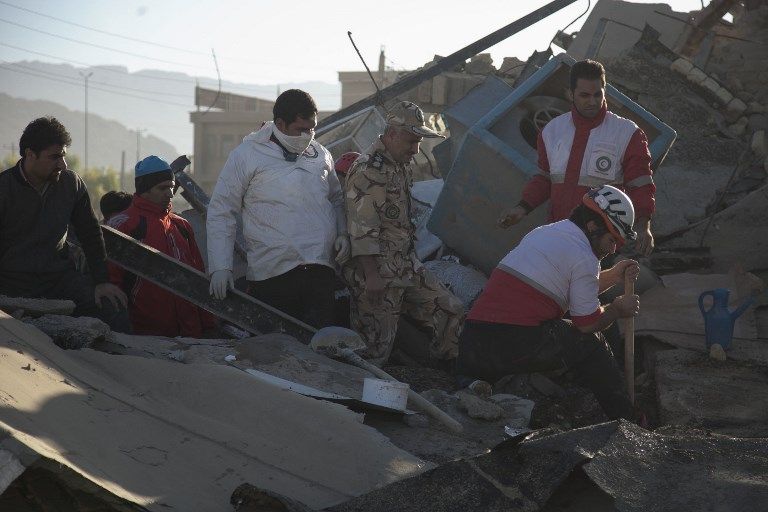 Los trabajadores de rescate buscan supervivientes en medio de los escombros después de un terremoto de 7.3 grados en Sarpol-e Zahab en la provincia occidental de Kermanshah, Irán, 13 de noviembre de 2017. (AFP / TASNIM NEWS / Farzad MENATI)