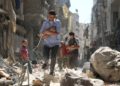 Hombres sirios que transportaban bebés se abrían paso entre los escombros de los edificios destruidos después de un ataque aéreo en el barrio de SALIHIN, en el norte de Alepo, controlado por los rebeldes, el 11 de septiembre. AMEER ALHALBI / AFP / GETTY