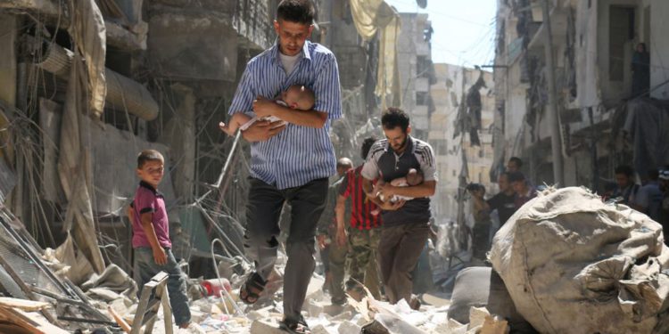 Hombres sirios que transportaban bebés se abrían paso entre los escombros de los edificios destruidos después de un ataque aéreo en el barrio de SALIHIN, en el norte de Alepo, controlado por los rebeldes, el 11 de septiembre. AMEER ALHALBI / AFP / GETTY