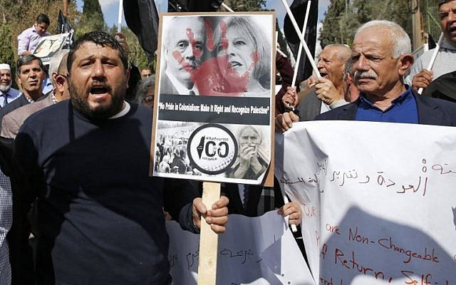 Manifestantes musulmanes sostienen un póster mientras se reúnen frente al Consulado británico en el este de Jerusalén, el 2 de noviembre de 2017, para protestar en el centenario de la Declaración Balfour de Gran Bretaña, que ayudó a la creación del Estado de  Israel. (AHMAD GHARABLI / AFP)
