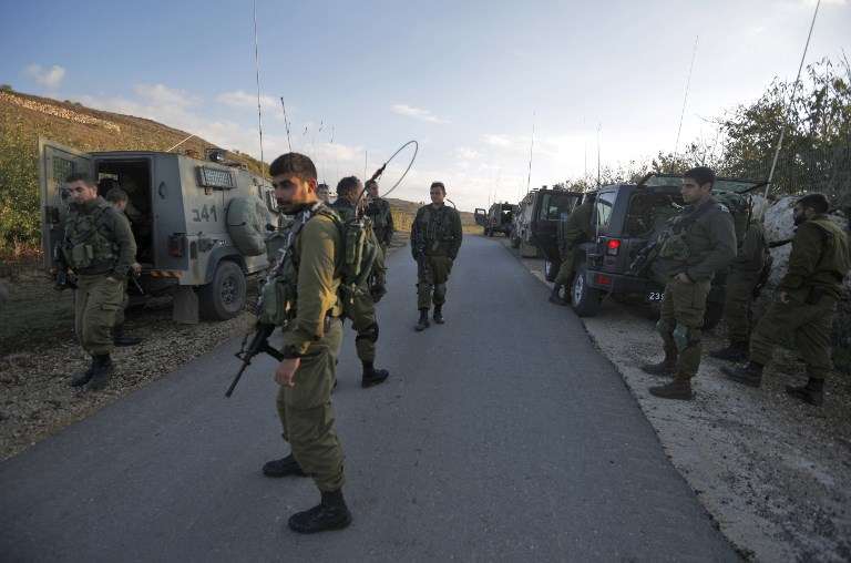 Soldados israelíes cierran una carretera cerca de la frontera en los Altos del Golán para evitar que los residentes drusos crucen a Siria después de un atentado suicida en la aldea siria drusa de Hader el 3 de noviembre de 2017. (Jalaa Marey / AFP)