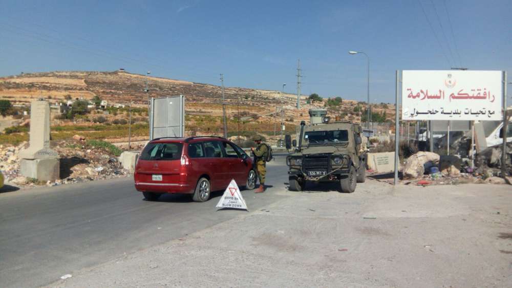 Soldados israelíes operan un puesto de control a la entrada de la aldea de Halhul, la ciudad natal de un terrorista musulmán  que embistió con su automóvil a dos israelíes más temprano en el día, el 17 de noviembre de 2017. (Fuerzas de Defensa de Israel)