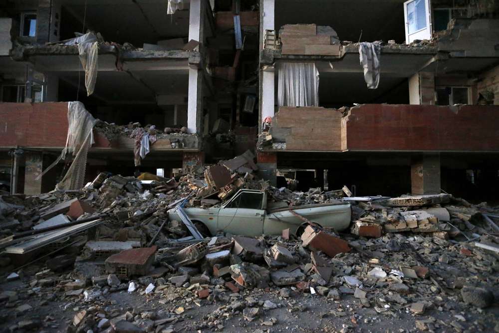 En esta foto provista por la Agencia de Noticias de los Estudiantes Iraníes, ISNA, un automóvil yace destrozado por escombros del terremoto en la ciudad de Sarpol-e-Zahab en el oeste de Irán, el lunes 13 de noviembre de 2017. (Pouria Pakizeh / ISNA via AP )