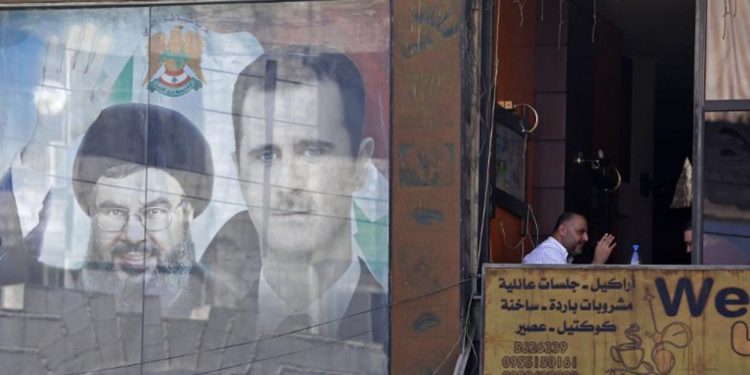 El 7 de septiembre de 2017 se ve un póster con la imagen del presidente sirio Bashar Assad (R) y el líder de Hezbolá Hassan Nasrallah en Damasco. (AFP / Louai Beshara)