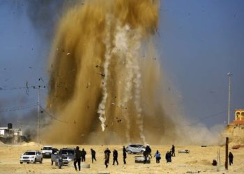 Ilustrativo: Árabes huyen mientras la arena y el humo suben después de un ataque aéreo israelí contra un puesto de Hamás en el norte de la Franja de Gaza el 6 de febrero de 2017. (Mohammed Abed / AFP)