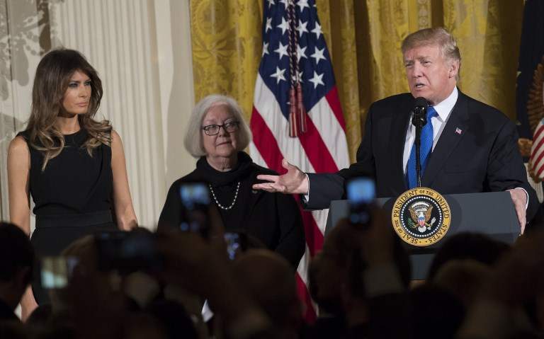 El presidente de EE.UU. Donald Trump habla junto con la Primera Dama Melania Trump (L) y la sobreviviente del Holocausto Louise Lawrence-Israels (C) durante una recepción de Januka en el Salón Este de la Casa Blanca en Washington, DC, el 7 de diciembre de 2017. (AFP PHOTO / SAUL LOEB)