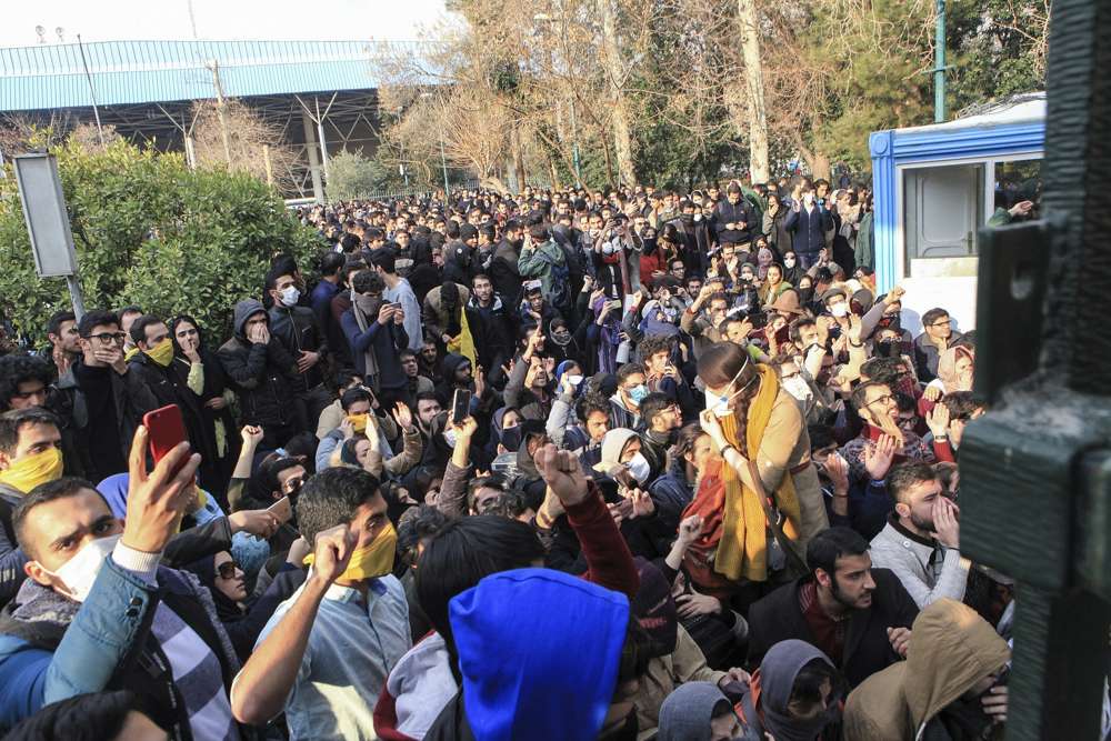 En esta foto tomada por un individuo no empleado por Associated Press y obtenida por la AP fuera de Irán, la policía iraní antidisturbios impide que estudiantes universitarios se unan a otros manifestantes sobre la economía débil de Irán, en Teherán, Irán, el 30 de diciembre de 2017. (AP )