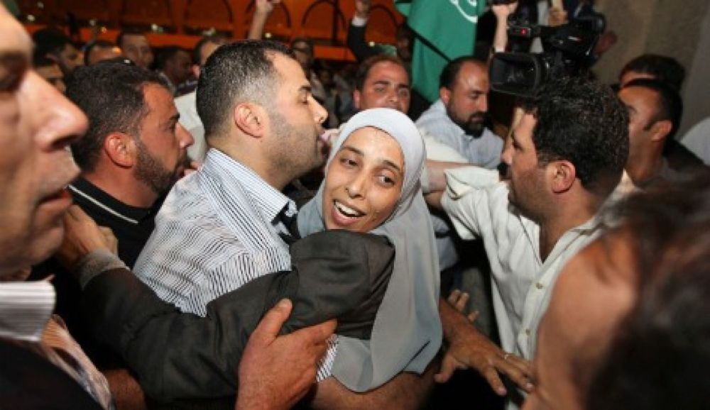 El jordano Ahlam Tamimi, recién liberado de una prisión israelí, fue abrazado por un pariente a su llegada al aeropuerto internacional Queen Alia en Amman el 18 de octubre de 2011. Reuters
