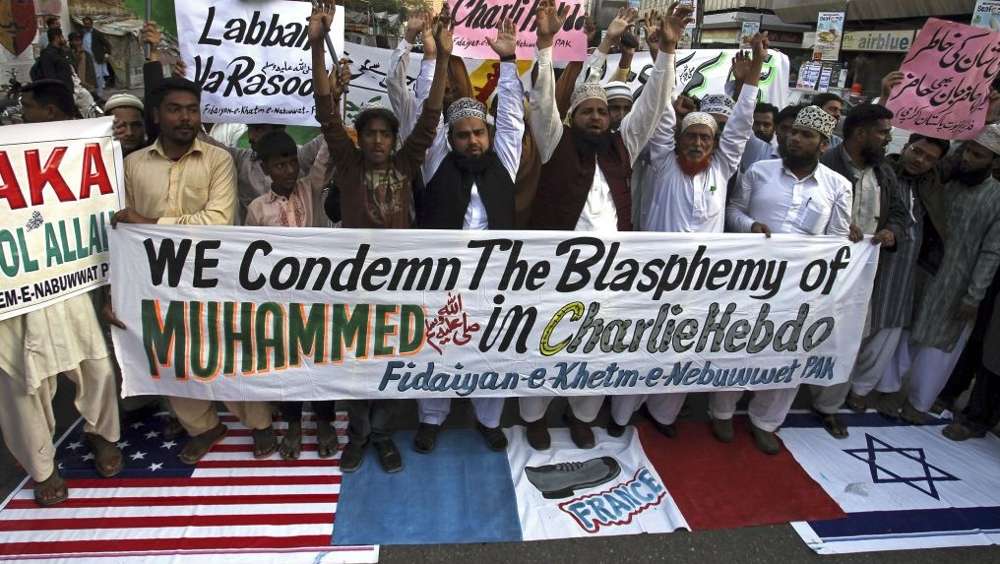 Los partidarios de un grupo religioso paquistaní 'Fidaiyan-e-Khetm-e-Nebuwwat' se colocan sobre banderas estadounidenses, francesas e israelíes durante una manifestación para protestar contra las caricaturas publicadas en la revista francesa Charlie Hebdo, en Karachi, Pakistán, el sábado 17 de enero de 2015 . (Crédito de la foto: AP / Fareed Khan)