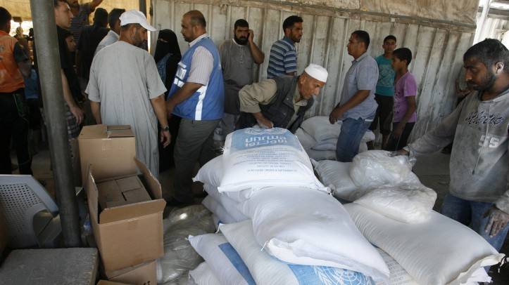 Los árabes reciben ayuda en un centro de distribución de las Naciones Unidas (UNRWA) en el campo de refugiados de Rafah, al sur de la Franja de Gaza el 31 de julio de 2014 (crédito de la foto: Abed Rahim Khatib / Flash 90)