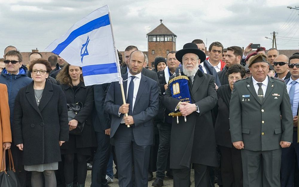 El ministro de Educación Naftali Bennett (2º-L), el rabino Meir Lau (2º-R) y el jefe de personal de las FDI Gadi Eisenkot (R) participan en la Marcha de los Vivos en el campamento de Auschwitz-Birkenau en Polonia el 24 de abril de 2017. (Yossi Zeliger / Flash 90)