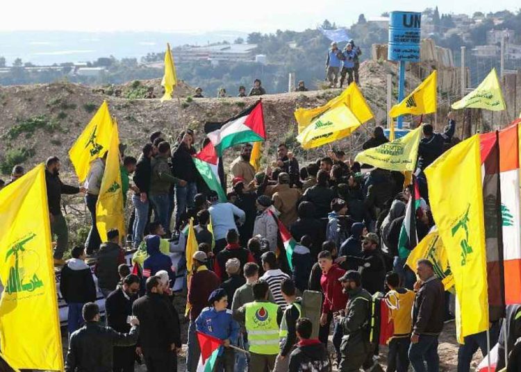 Soldados israelíes (arriba L) y fuerzas de paz de la ONU (arriba R) observan a los partidarios libaneses del movimiento chiita de Hezbollah presencian una manifestación contra la decisión del presidente estadounidense de reconocer a Jerusalem como la capital de Israel el 28 de enero de 2018 en la aldea libanesa del sur de Alma al-Shaab, en la frontera con Israel. (AFP / Mahmoud Zayyat)