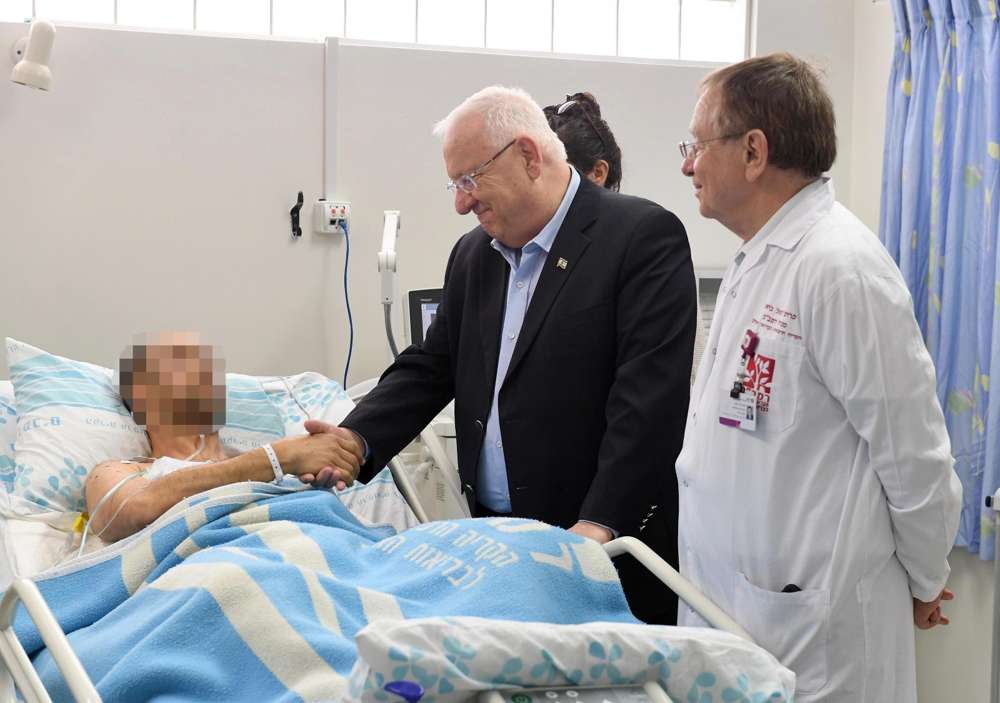 El presidente Reuven Rivlin visitando a los pilotos de las FDI heridos cuando un F-16 israelí fue derribado a su regreso de Siria, el 11 de febrero de 2018. (Mark Neiman / GPO)
