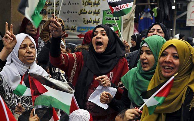 Mujeres árabes gritan consignas mientras sostienen banderas palestinas durante una sentada en el campamento de refugiados palestinos de Bourj al-Barajneh, en Beirut, Líbano, el 6 de diciembre de 2017. (AP Photo / Bilal Hussein)