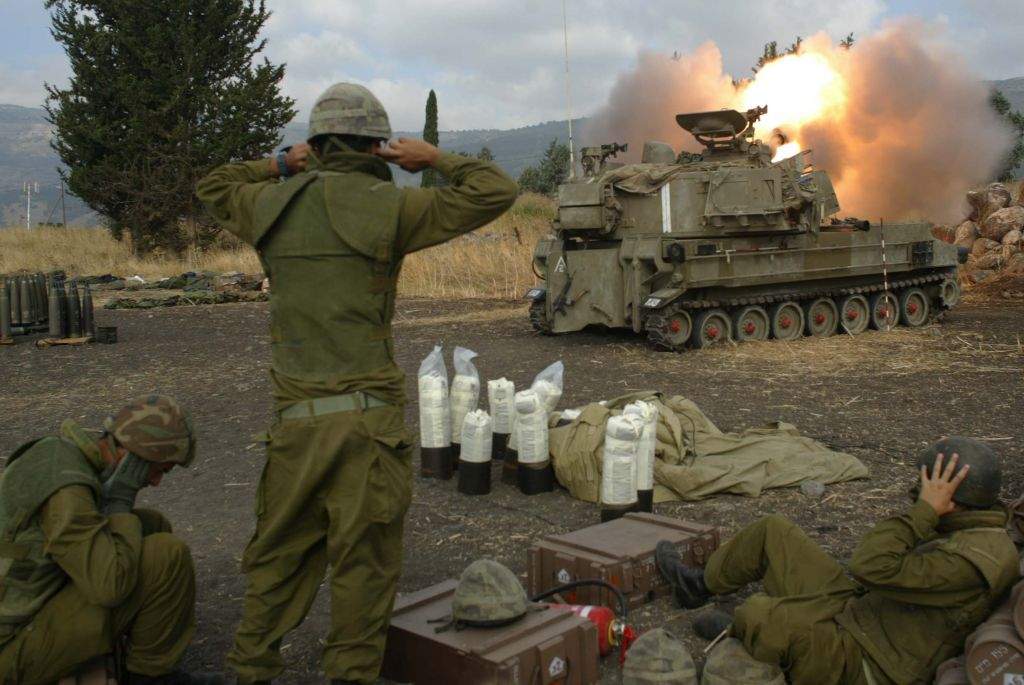 Soldados israelíes se cubren los oídos mientras disparan proyectiles de artillería en el sur del Líbano desde las afueras de Kiryat Shmona, en el norte de Israel, durante la Segunda Guerra del Líbano, el 22 de julio de 2006. (Pierre Terdjman / Flash 90)