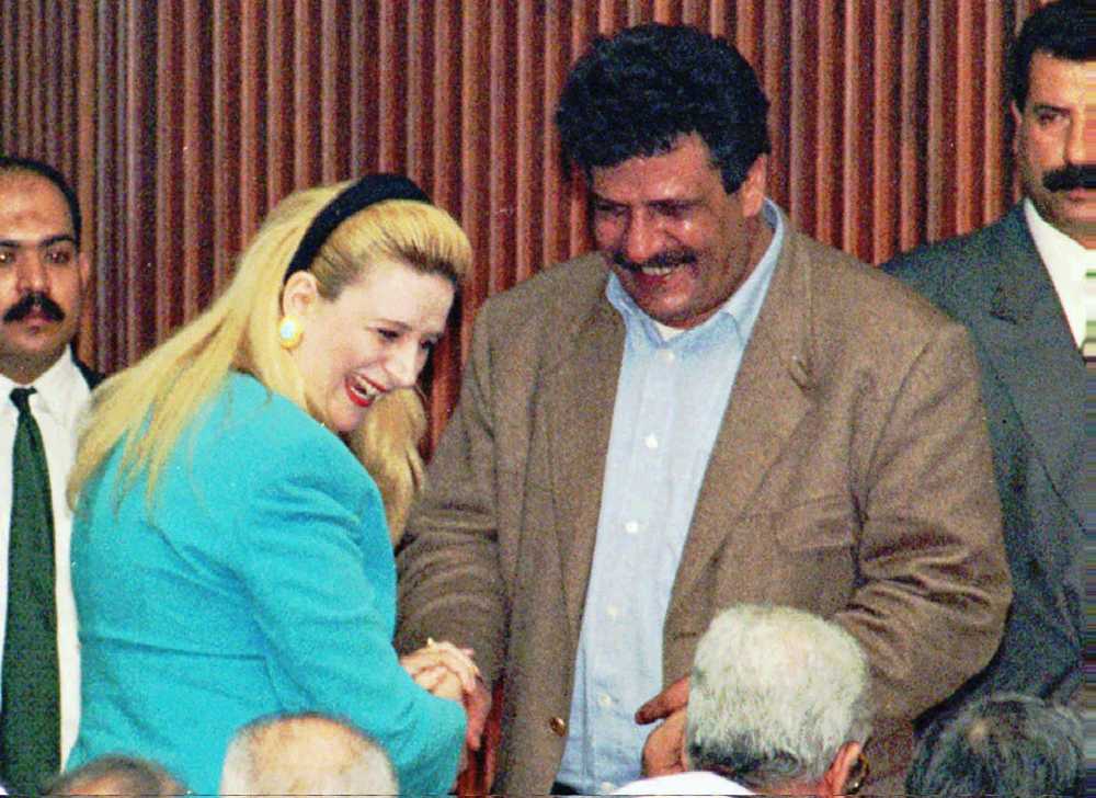 Suha Arafat, esposa del líder de la OLP Yasser Arafat, saluda al cerebro del secuestro del Achille Lauro, Abul Abbas, antes del inicio de la primera sesión del Consejo Nacional Palestino en la ciudad de Gaza, el 22 de abril de 1996. (AP / Adel Hana)