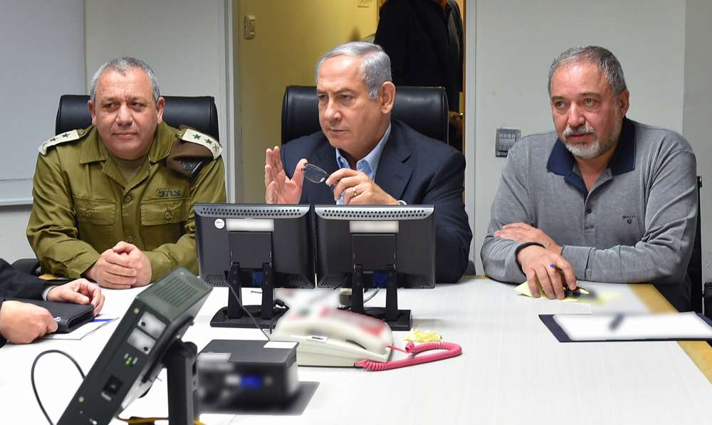 El primer ministro Benjamin Netanyahu, centro, recibe información sobre la escalada en la frontera norte junto con el jefe de personal de las FDI Gadi Eisenkot, izquierda, y el ministro de Defensa Avigdor Liberman, derecha, el 10 de febrero de 2018. (Ariel Hermoni / Ministerio de Defensa)