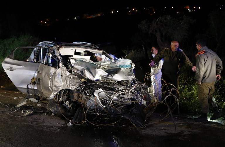 Las fuerzas de seguridad israelíes y expertos forenses inspeccionan el vehículo destruido que fue utilizado por un terrorista palestino en un ataque con coche contra soldados israelíes cerca del asentamiento de Mevo Dotan en Samaria el 16 de marzo de 2018. (AFP Photo / Jack Guez)