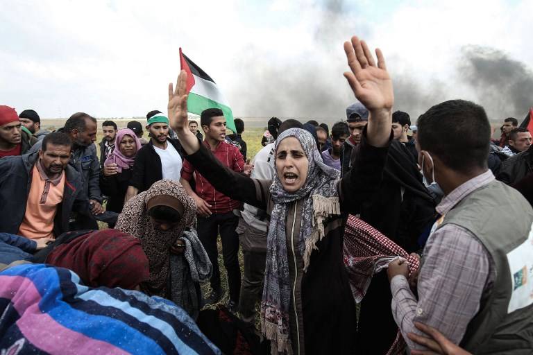 Los manifestantes palestinos agitan la bandera de la revuelta árabe durante una manifestación conmemorativa del Día de la Tierra, cerca de la frontera con Israel, al este de la ciudad de Gaza, el 30 de marzo de 2018. (AFP / Hams de Mahmud)