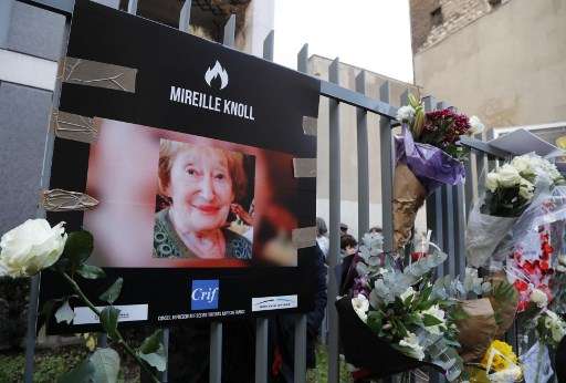 Una fotografía de Mireille Knoll y flores que se colocaron en la valla que rodea su edificio en París el 28 de marzo de 2018. (Francois Guillot / AFP)