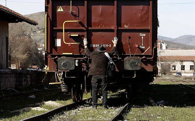 Un judío pone sus manos en un vagón de carga, durante una conmemoración de las víctimas del Holocausto en la estación de ferrocarril de Bitola, en el sur de Macedonia, el 11 de marzo de 2018. (AP Photo / Boris Grdanoski)