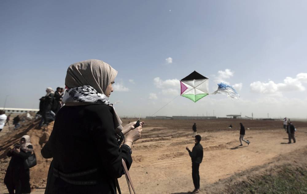 Los manifestantes palestinos vuelan cometas durante una manifestación cerca de la frontera de la Franja de Gaza con Israel, en el este de la ciudad de Gaza, el 29 de marzo de 2018. (AP Photo / Khalil Hamra)