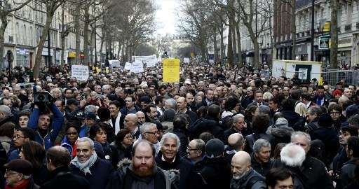 Los participantes caminan detrás sosteniendo pancartas durante una marcha silenciosa en París en memoria de Mireille Knoll, una mujer judía de 85 años asesinada en su casa por un musulmán y su cómplice, el 28 de marzo de 2018. (Francois Guillot / AFP)