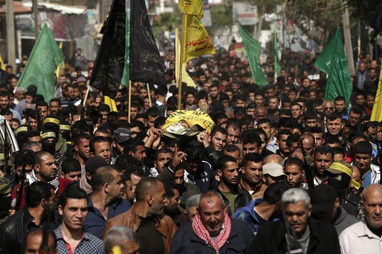 Árabes palestinos llevan el cadáver de Hamdan Abu Amsha, muerto el día anterior por fuego israelí durante una protesta masiva en la frontera a lo largo de la valla de seguridad, en Beit Hanoun, al norte de la Franja de Gaza, el 31 de marzo de 2018. (AFP / MAHMUD HAMS)