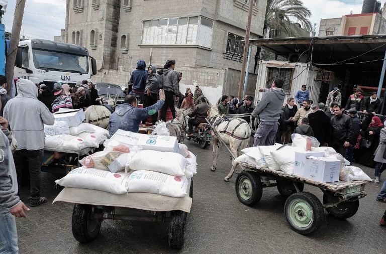 Árabes recogen paquetes de ayuda en un centro de distribución de alimentos de las Naciones Unidas en Khan Yunis, al sur de la Franja de Gaza, el 28 de enero de 2018. (Said Khatib / AFP)