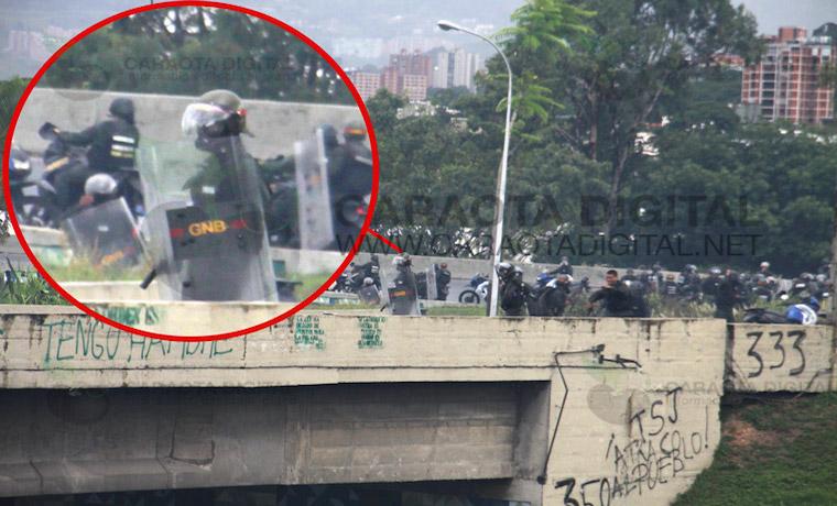 En las imágenes fue captado un uniformado con casco y otro sin él, quienes arremetieron hacia los manifestantes con armas de fuego a la altura del Distribuidor de Altamira. | Caracol Digital