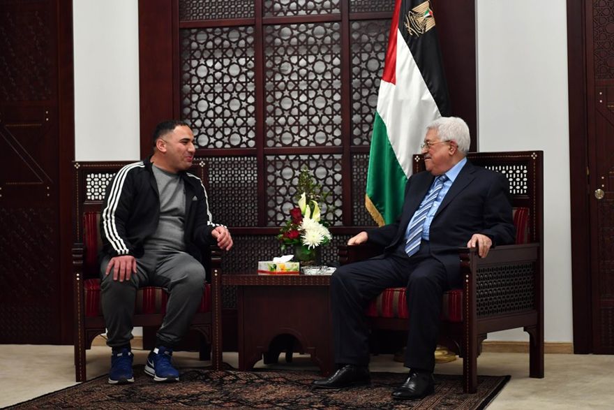 El presidente de la Autoridad Palestina Mahmoud Abbas (r) se reúne con Rajaei Haddad, quien pasó 20 años en las prisiones israelíes por su participación en un ataque terrorista en 1997 que mató a Gabriel Hirschberg. (WAFA / Thaer Ghanaim)