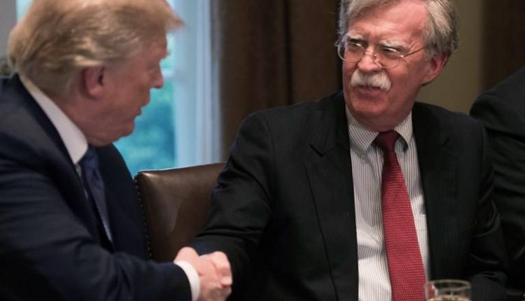 El presidente estadounidense, Donald Trump, estrecha la mano del asesor de Seguridad Nacional, John Bolton, durante una reunión con altos líderes militares en la Casa Blanca, el 9 de abril de 2018. (AFP Photo / Nicholas Kamm)