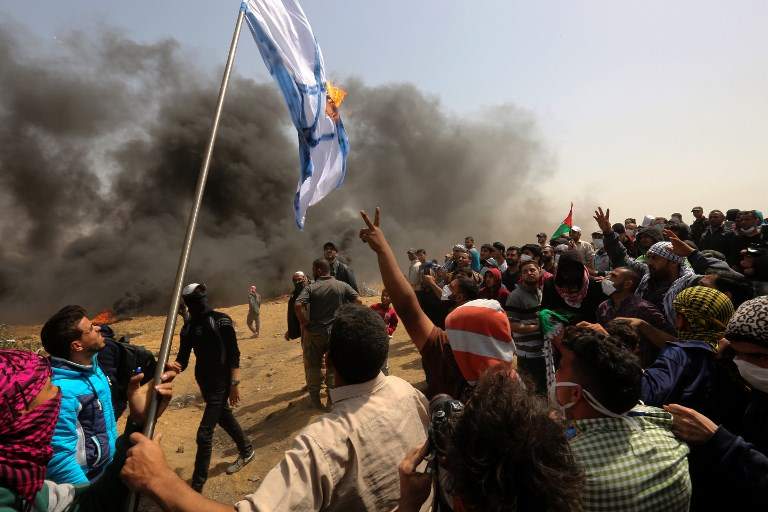 Los islamistas palestinos queman una bandera israelí durante las violentas manifestaciones contra las fuerzas israelíes cerca de la frontera con Israel, al este de la ciudad de Gaza en la franja central de Gaza, el 13 de abril de 2018. (/ AFP PHOTO / MAHMUD HAMS)